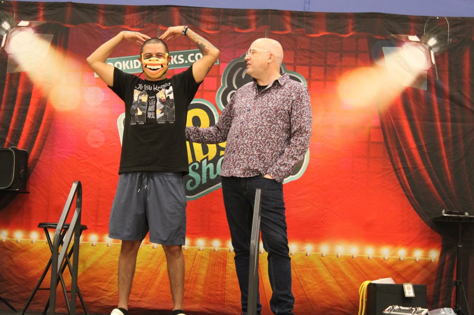 Tim having fun with a dad volunteer on stage at the Family Night Show