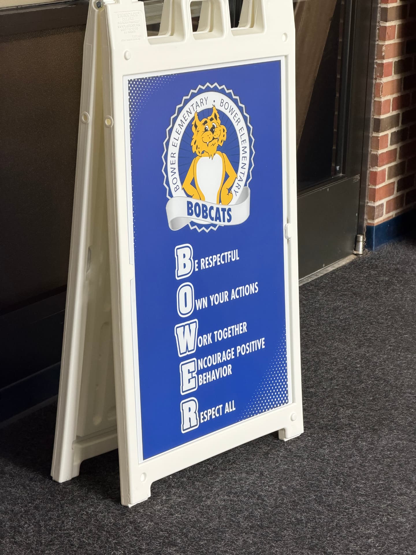 A sidewalk sign at Bower Elementary listing the BOWER character expectations