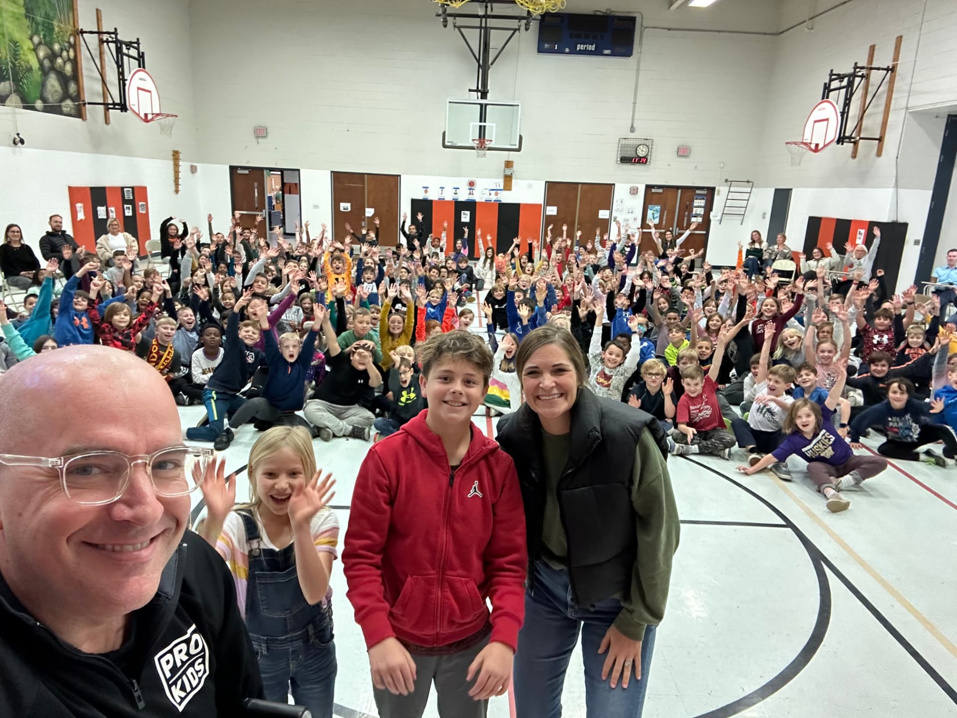 Tim Hannig with a student and staff member at Wiesbrook Elementary, years after the first visit